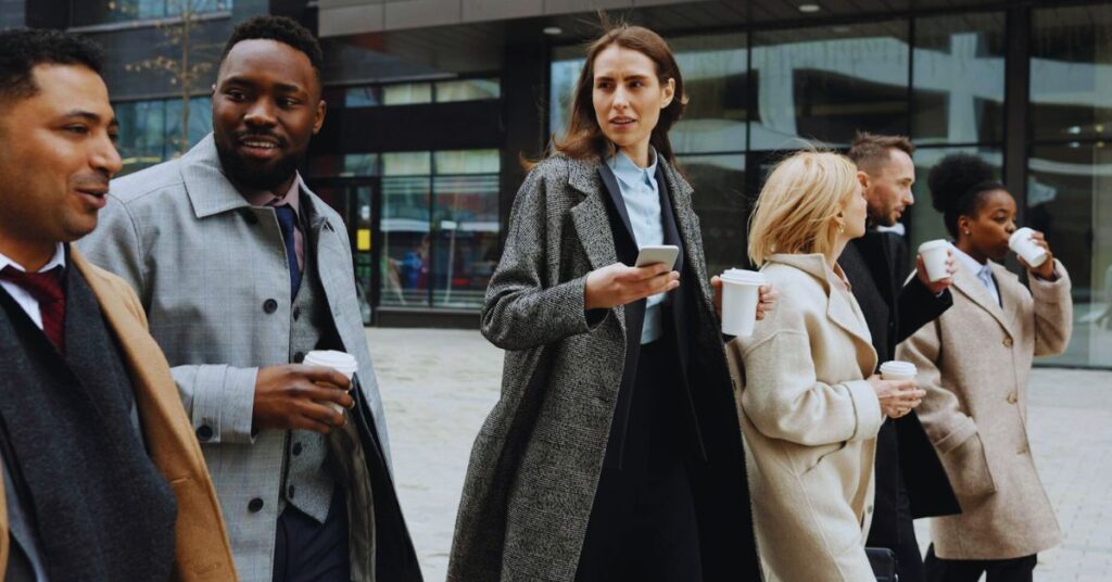 Group of busy professionals walking and talking drinking coffee.